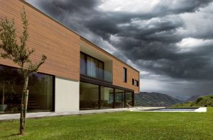 Residential home with plank metal siding with a cloudy sky